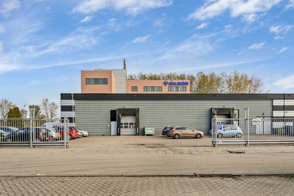 Bedrijfsgebouw van Gilson aan de Laan van ’s-Gravenmade met parkeerplaatsen en laadperrons op de voorgrond.